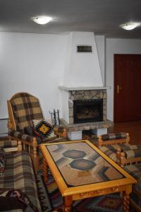 uma sala de estar com uma mesa e uma lareira em Хотел-механа Павлова къща em Chiprovtsi