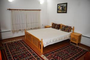 Dormitorio pequeño con cama y alfombra en Хотел-механа Павлова къща en Chiprovtsi