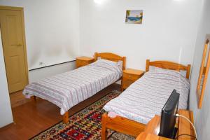 a room with two beds and a tv in it at Хотел-механа Павлова къща in Chiprovtsi