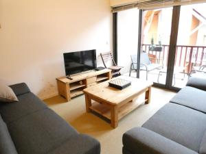 a living room with a couch and a tv and a table at Duplex T4 8 pers, 102m², Saint-Lary-Soulan, Balcon, Garage, 3 Chambres, 3⭐️, Proche Centre - FR-1-457-278 in Saint-Lary-Soulan