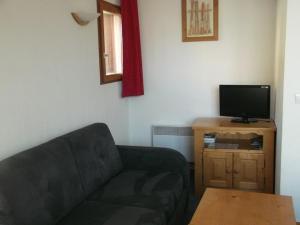 ein Wohnzimmer mit einem Sofa und einem Flachbild-TV in der Unterkunft Appartement Orcières Merlette, 3 pièces, 6 personnes - FR-1-262-167 in Orcières