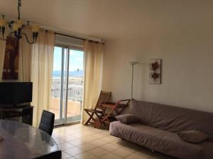 a living room with a couch and a glass table at Appartement Le Barcarès, 3 pièces, 6 personnes - FR-1-81-497 in Le Barcarès