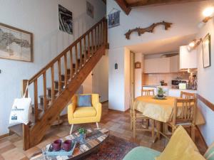 a living room and kitchen with a staircase and a table at Doux Duplex à 6 dans Saint-Lary-Soulan - FR-1-296-291 in Saint-Lary-Soulan