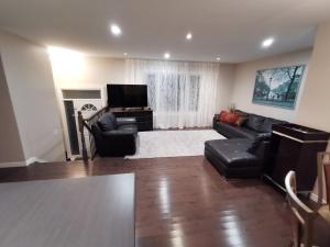 a living room with a couch and a tv at Beautiful 3 bedroom house in Ottawa