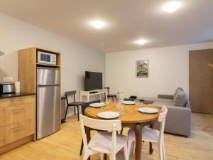 eine Küche und ein Esszimmer mit Tisch und Stühlen in der Unterkunft Appartement central 4-9 personnes avec parking à Cauterets - FR-1-401-181 in Cauterets + 3 Fotos