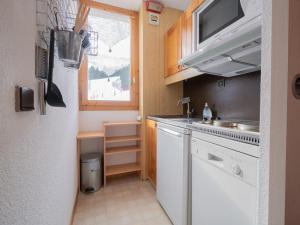 Una pequeña cocina con fregadero y ventana. en Appartement cosy 4 pers, Animaux acceptés, Parking dispo - FR-1-291-845, en Valmorel