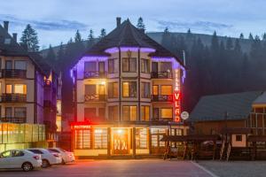 a large building with purple lights on it at Villa Vlad & Spa in Bukovel