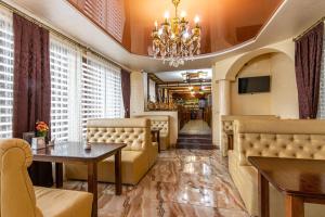 a restaurant with couches and a table and a chandelier at Villa Vlad & Spa in Bukovel