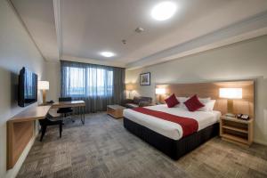 a bedroom with a large bed and a large window at Bunbury Hotel Koombana Bay in Bunbury