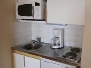 cocina con fregadero y microondas en Appartement Les Adrets-Prapoutel, 1 pièce, 3 personnes - FR-1-557-80, en Les Adrets