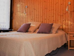 - une chambre avec un grand lit et des murs en bois dans l'établissement Appartement Le Grand-Bornand, 3 pièces, 6 personnes - FR-1-241-222, au Grand-Bornand