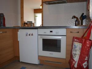 La cuisine est équipée d'une cuisinière blanche et d'un réfrigérateur. dans l'établissement Appartement Le Grand-Bornand, 3 pièces, 6 personnes - FR-1-241-222, au Grand-Bornand