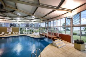 a pool in a large building with a lobby at Bunbury Hotel Koombana Bay in Bunbury