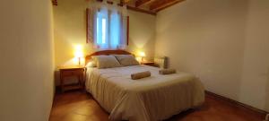 a bedroom with a large bed with two lamps on two tables at Donde Elvira in Valderromán