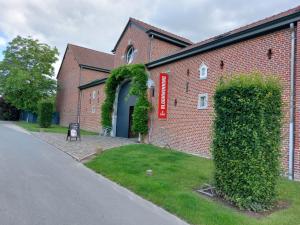 哈瑟尔特布鲁恩宁住宿加早餐酒店的街道上带有拱门的砖砌建筑