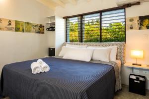 a bedroom with a bed with two towels on it at El Encuentro Surf Lodge in Cabarete