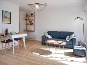 sala de estar con sofá azul y mesa en Appartement Carnac, 2 pièces, 4 personnes - FR-1-477-177, en Carnac
