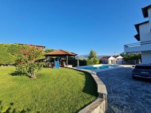 a yard with a swimming pool and a house at Villa ChrysPa Attica in Dhílesi