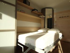 a bedroom with a large bed with white sheets at Studio rénové 4 pers à Saint-Chaffrey avec balcon, classé 3 étoiles - FR-1-330E-117 in Saint-Chaffrey