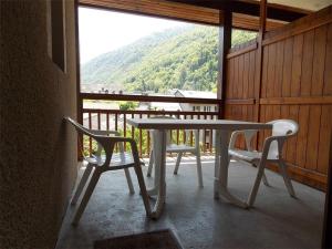 a table and two chairs on a balcony with a view at Studio Bagnères-de-Luchon, 1 pièce, 4 personnes - FR-1-313-130 in Luchon