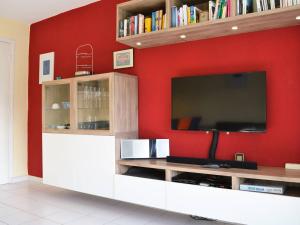 a living room with a tv and a red wall at Appartement Bormes-les-Mimosas, 3 pièces, 6 personnes - FR-1-251-371 in Bormes-les-Mimosas