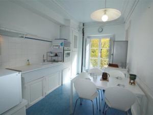 a white kitchen with a table and chairs in it at Grand T2 Ensoleillé à Luchon, Face aux Thermes, pour 4 Pers., Proche Télécabine - FR-1-313-165 in Luchon +6 photos