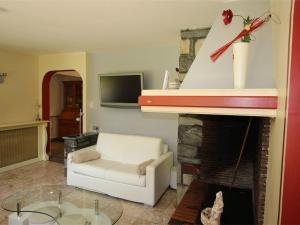 ein Wohnzimmer mit einer weißen Couch und einem Kamin in der Unterkunft Appartement Bagnères-de-Luchon, 3 pièces, 6 personnes - FR-1-313-177 in Luchon
