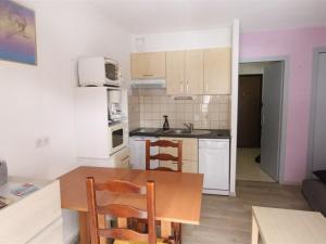 a small kitchen with a wooden table and a table and chairs at Studio Bagnères-de-Luchon, 1 pièce, 4 personnes - FR-1-313-183 in Luchon