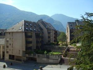 a group of buildings with mountains in the background at Studio Bagnères-de-Luchon, 1 pièce, 4 personnes - FR-1-313-183 in Luchon