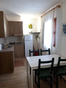 kuchnia i jadalnia ze stołem i krzesłami w obiekcie La tana del Lupo w mieście Falcade
