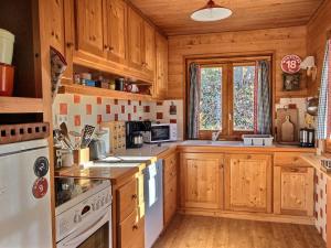 a kitchen with wooden cabinets and a white stove top oven at Chalet Peisey-Vallandry, 5 pièces, 10 personnes - FR-1-411-683 in Landry