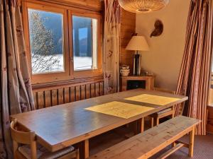 a wooden table in a room with a window at Chalet 10 pers au calme à 1 km de la station, 5 pièces avec WiFi et parking - FR-1-411-683 in Landry +5 photos