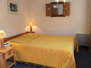 - une chambre avec un lit jaune et un miroir dans l'établissement Appartement Vars, 1 pièce, 6 personnes - FR-1-330B-174, à Vars