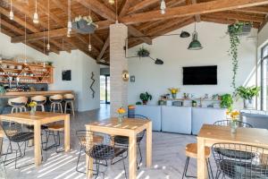 a room with tables and chairs and a kitchen at Langre Beach Surf Lodge in Galizano