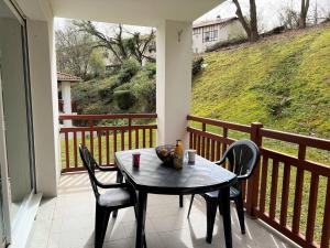 einen Tisch und Stühle auf einem Balkon mit Aussicht in der Unterkunft Appartement Cambo-les-Bains, 2 pièces, 2 personnes - FR-1-495-95 in Cambo-les-Bains