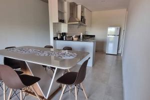 Una cocina con una mesa y sillas en una cocina. en Cómodo apartamento nuevo, zona aeropuerto!, en Luque