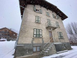 un edificio en la nieve con nieve cayendo sobre él en Appartement Praz-sur-Arly, 2 pièces, 4 personnes - FR-1-603-6, en Praz-sur-Arly