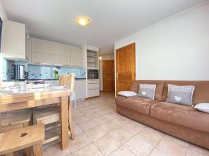 uma sala de estar com um sofá e uma cozinha em Appartement Praz-sur-Arly, 2 pièces, 6 personnes - FR-1-603-10 em Praz-sur-Arly