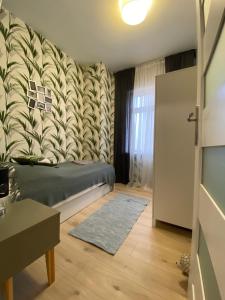 a small room with a bed and a wall at Apartamenty Cieplicka 20a in Jelenia Góra