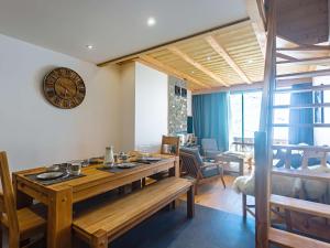 a dining room with a table and a clock on the wall at Appt 10 pers rénové, calme, balcon sud, cheminée, Wi-Fi, proche pistes - FR-1-545-14 in Val Thorens