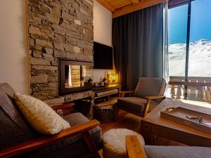 a living room with a fireplace and a stone wall at Appt 10 pers rénové, calme, balcon sud, cheminée, Wi-Fi, proche pistes - FR-1-545-14 in Val Thorens