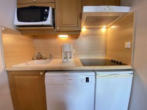 a small kitchen with a sink and a microwave at Appartement Praz-sur-Arly, 1 pièce, 4 personnes - FR-1-603-18 in Praz-sur-Arly