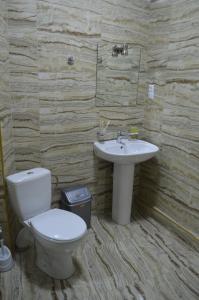 a bathroom with a toilet and a sink at Renaissance Hotel Tbilisi in Tbilisi City