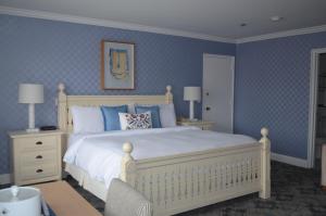 una camera da letto con un letto bianco e pareti blu di Southampton Inn a Southampton