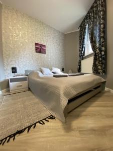 a bedroom with a large bed and a window at Apartamenty Cieplicka 20a in Jelenia Góra