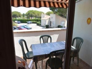 einen Tisch und Stühle auf einem Balkon mit Blick auf einen Parkplatz in der Unterkunft Appartement Cap d'Agde, 3 pièces, 5 personnes - FR-1-607-66 in Cap d'Agde