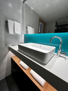 a bathroom with a white sink and a blue wall at Holiday Inn Express - Madrid - Airport, an IHG Hotel in Madrid