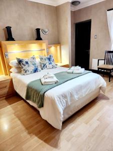 a bedroom with a large bed with two towels on it at The Wooden Leg Guesthouse in Kleinmond +23 photos