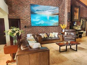 a living room with couches and a brick wall at The Wooden Leg Guesthouse in Kleinmond