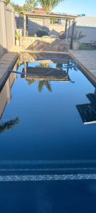 a pool with blue water in a yard at The Wooden Leg Guesthouse in Kleinmond